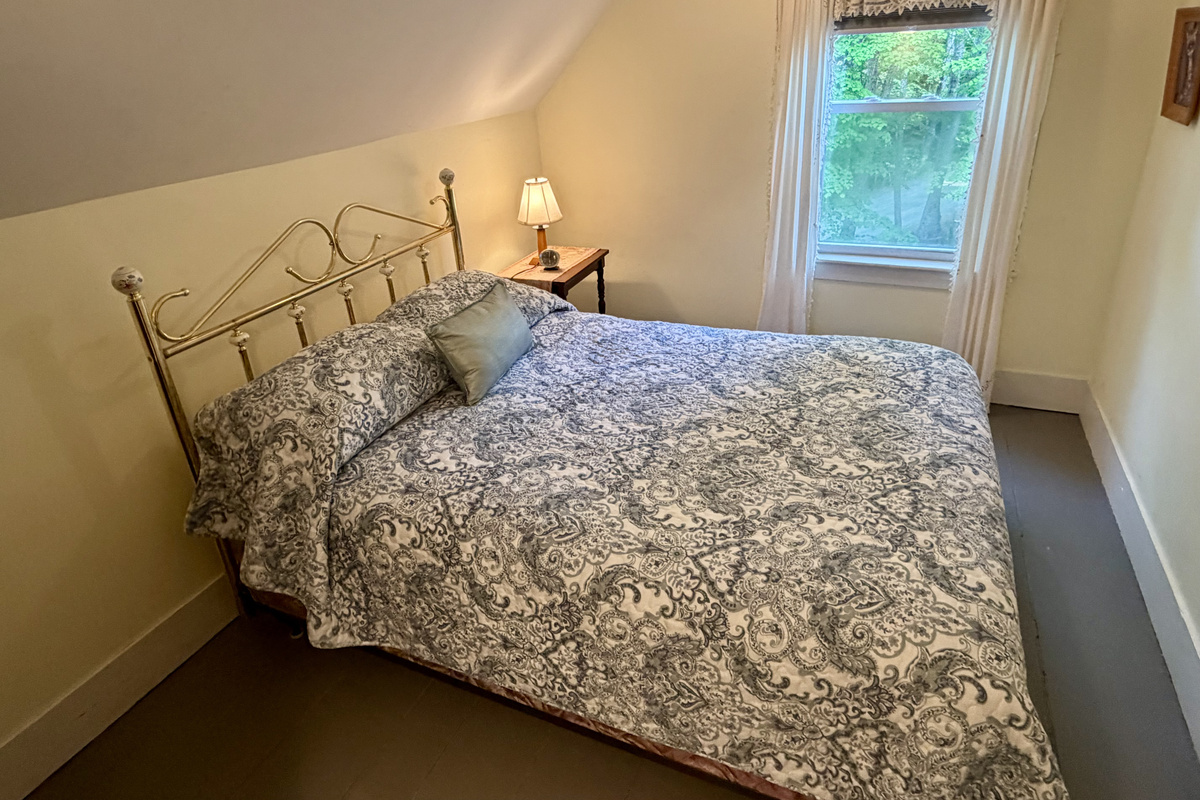 Wake up to peaceful views of the Maine woods from the refreshed guest bedroom. This bright, cozy space combines historic cottage architecture with comfortable modern updates, providing a quiet haven just minutes from Acadia.