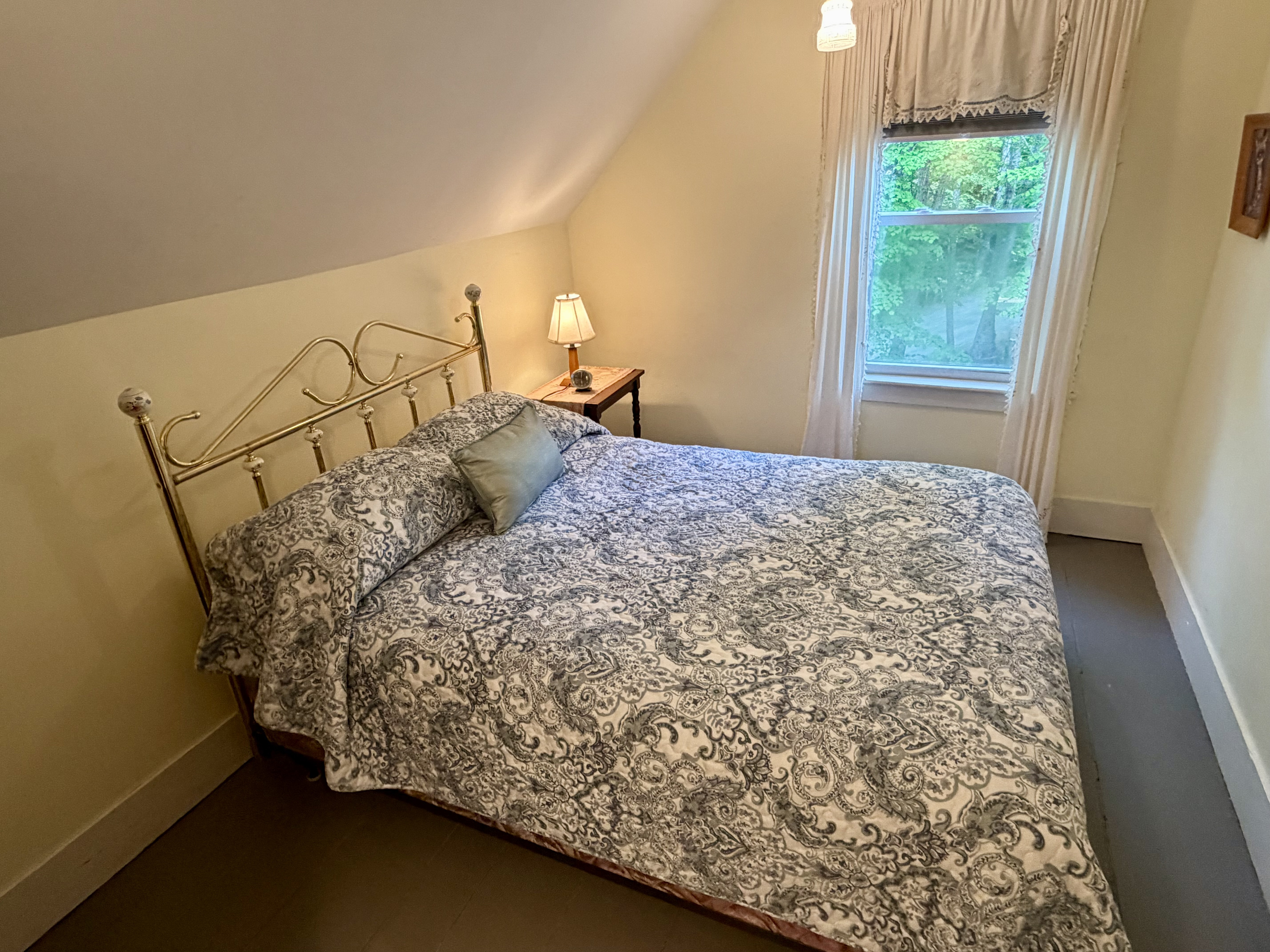 Wake up to peaceful views of the Maine woods from the refreshed guest bedroom. This bright, cozy space combines historic cottage architecture with comfortable modern updates, providing a quiet haven just minutes from Acadia.