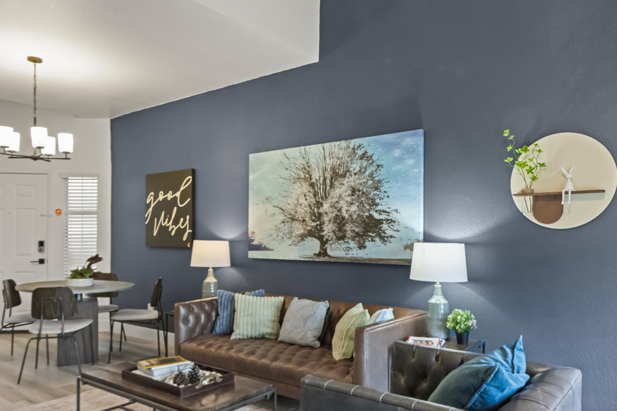 Relax in the beautifully furnished living room featuring a comfortable sofa, accent chairs, large TV, and tasteful modern décor.