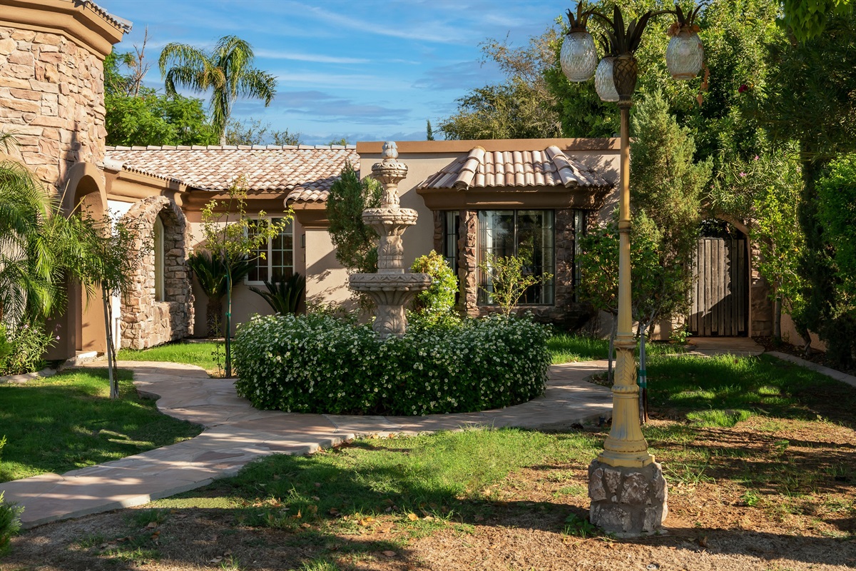 Lush landscaping and a sunlit courtyard welcome you to this elegant desert retreat with timeless architectural beauty.