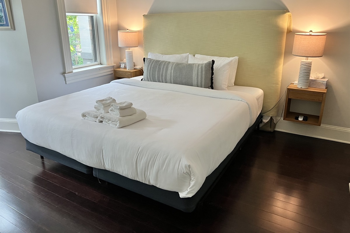 Spacious main bedroom with a newly upgraded plush Serta king bed, tranquil tree-lined views, and a 40" Samsung 4K Smart TV—perfect for rest, relaxation, and streaming.