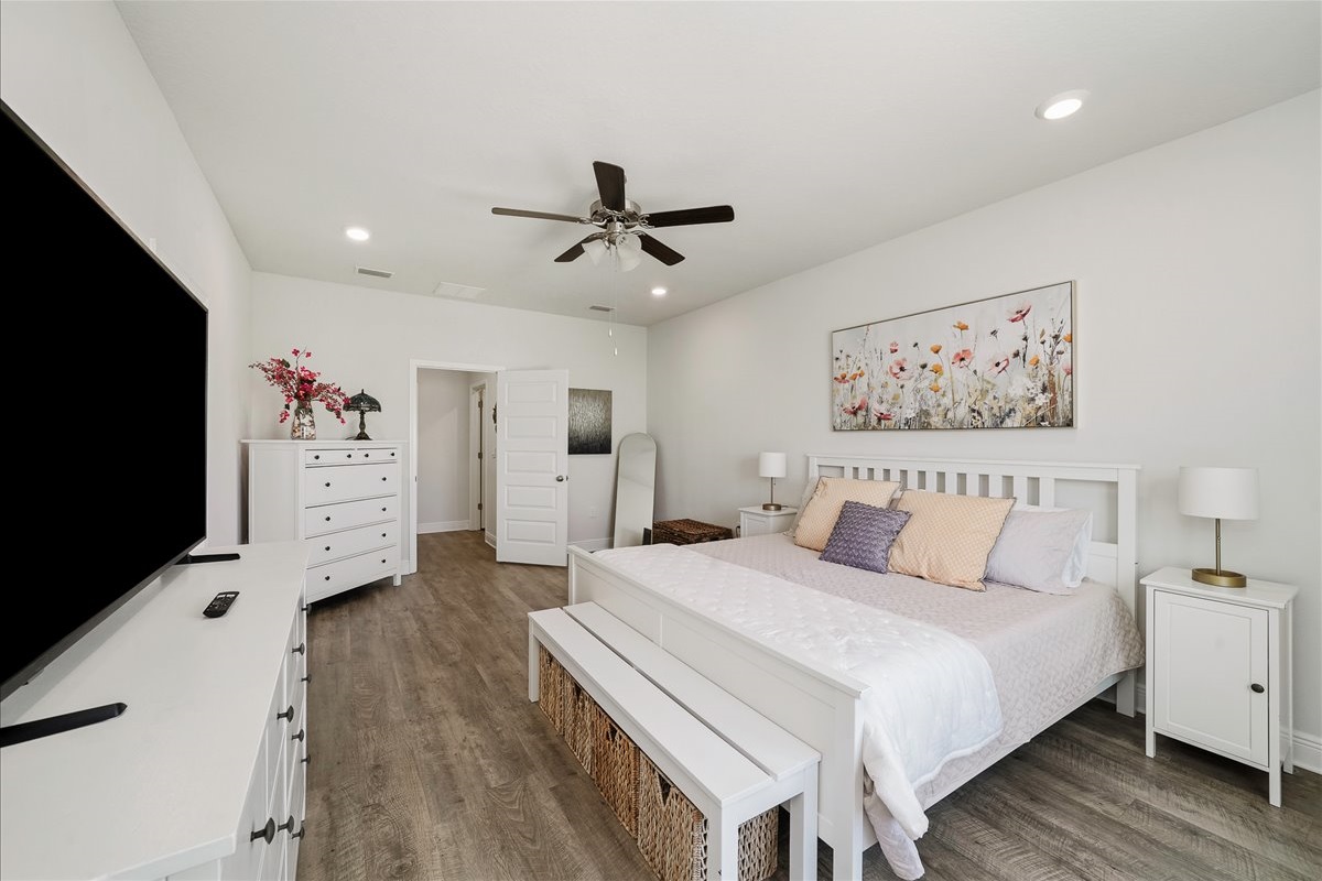 Primary Suite: Relax in a spacious King bed with premium linens, a ceiling fan for comfort, Smart TV, and a cozy bench, your perfect retreat after a long day.