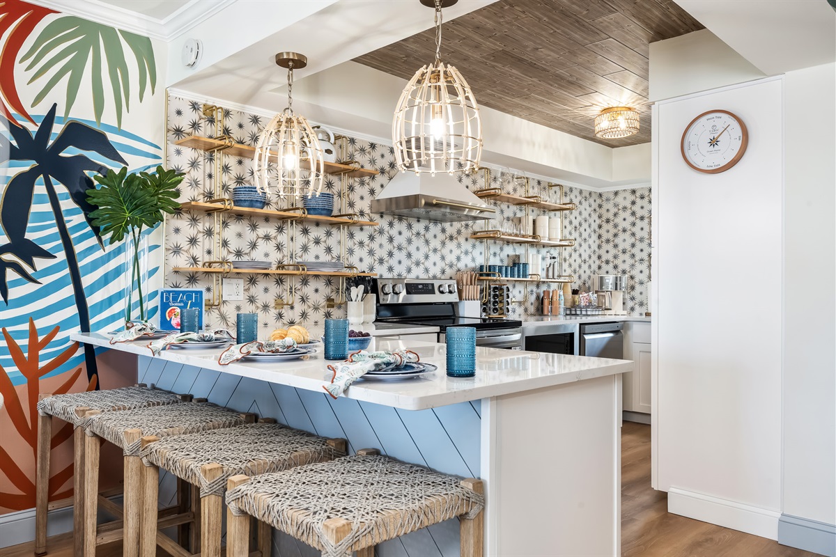 Stylish open kitchen with modern appliances and a coastal-chic design.