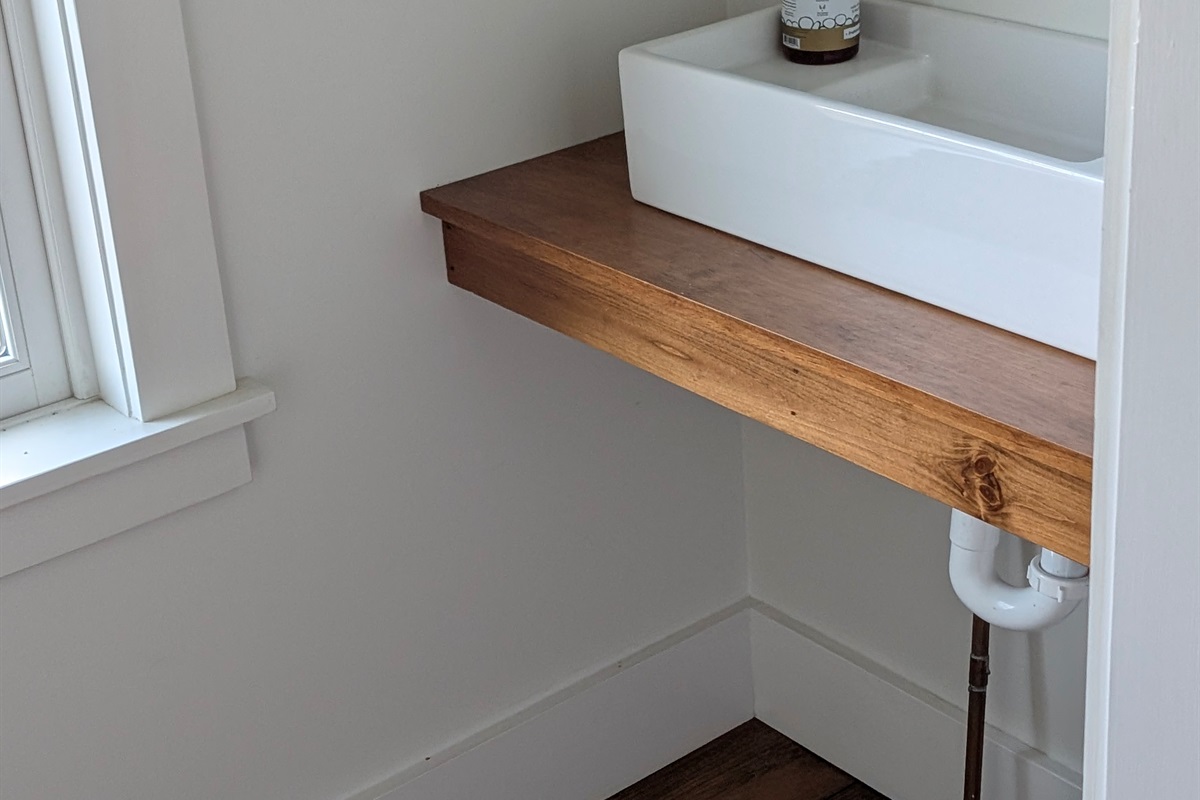 Thoughtful details throughout — handcrafted wood shelving and clean, modern finishes.