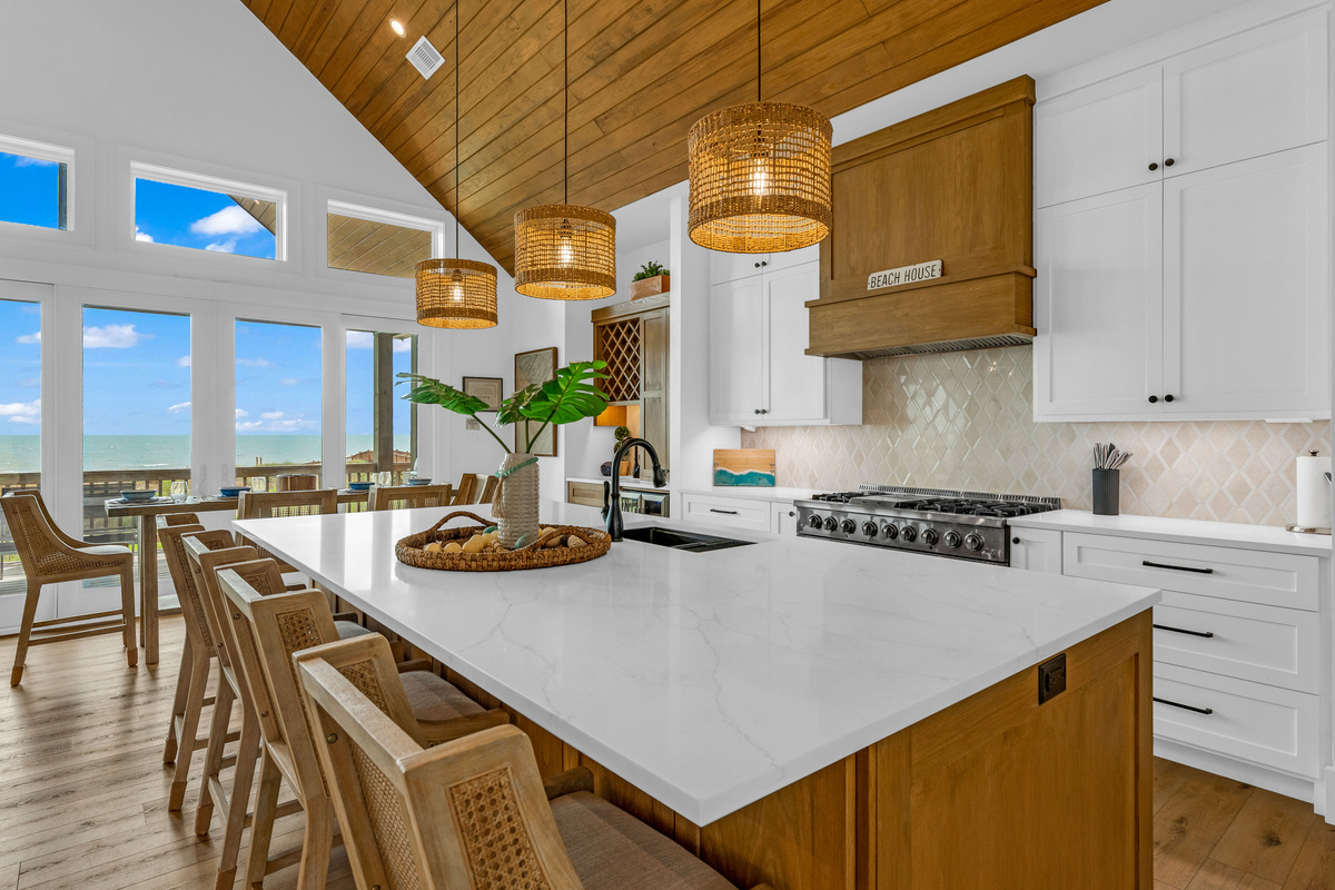 Cair Paravel: Chef’s kitchen with high-end appliances and quartz countertops. Built-in bar area with wine fridge and glassware storage.