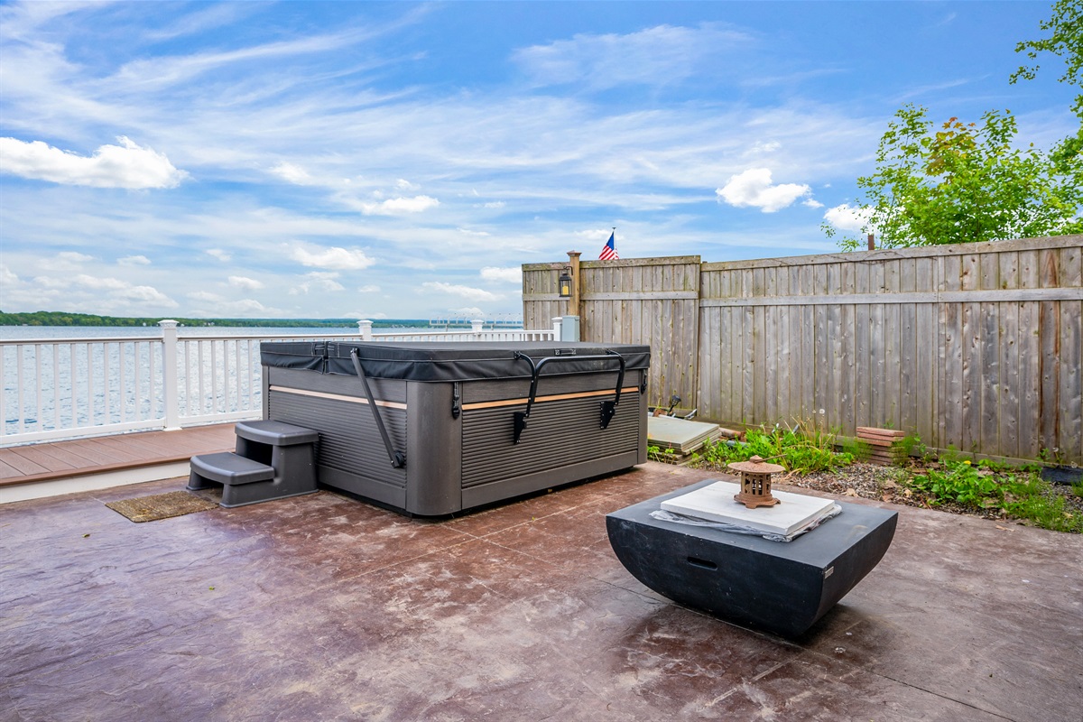 Unwind in the lakeside hot tub with endless water views and a cozy fire table to set the mood 🌊🔥🛁