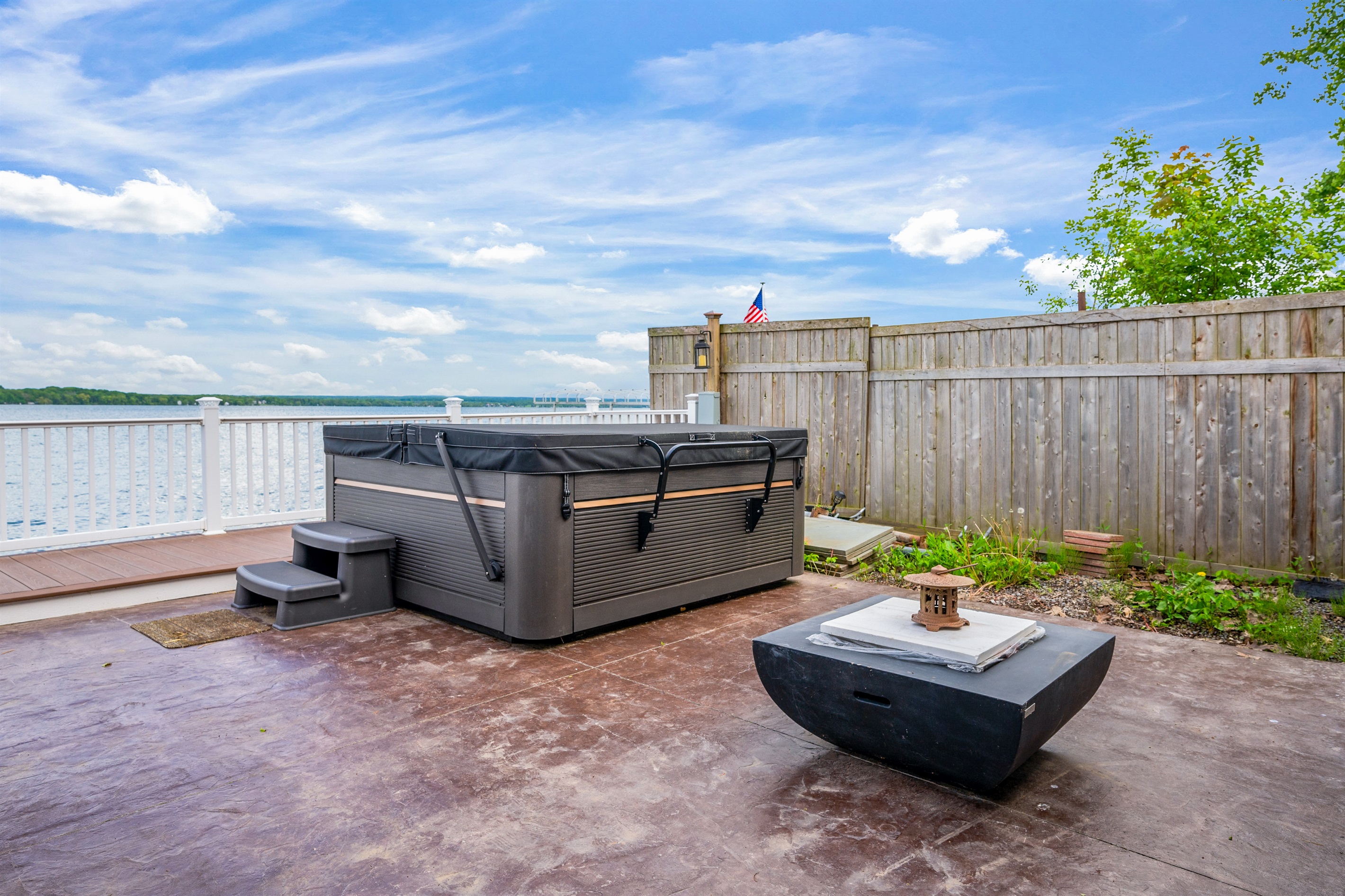 Unwind in the lakeside hot tub with endless water views and a cozy fire table to set the mood 🌊🔥🛁