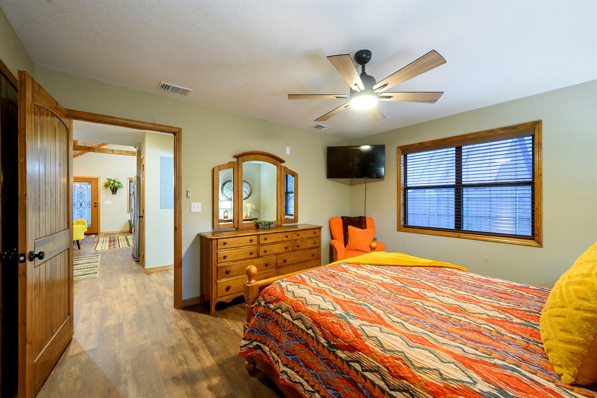 The bedroom has a queen bed and smart TV.