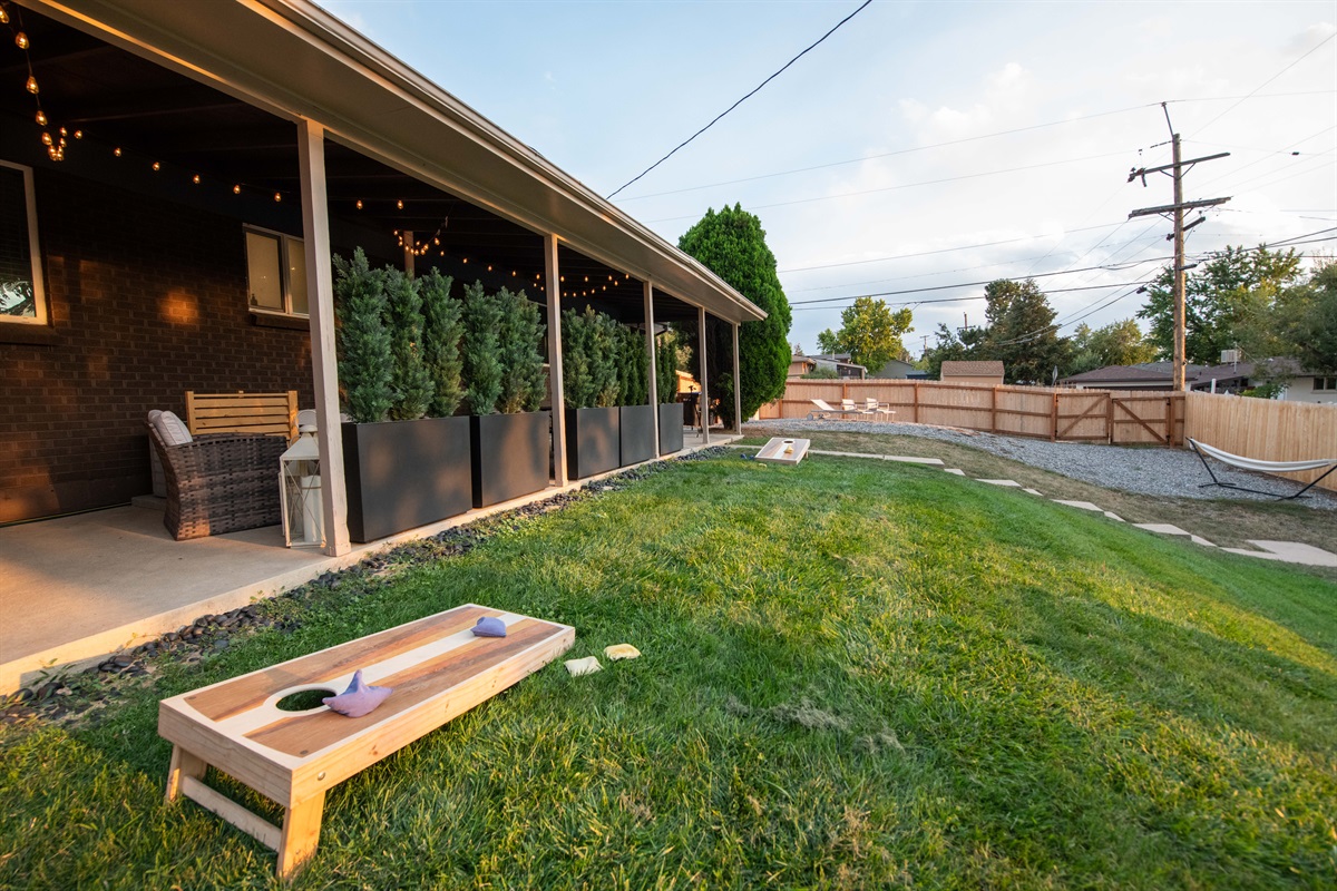 Spacious backyard with cornhole and covered lounging area