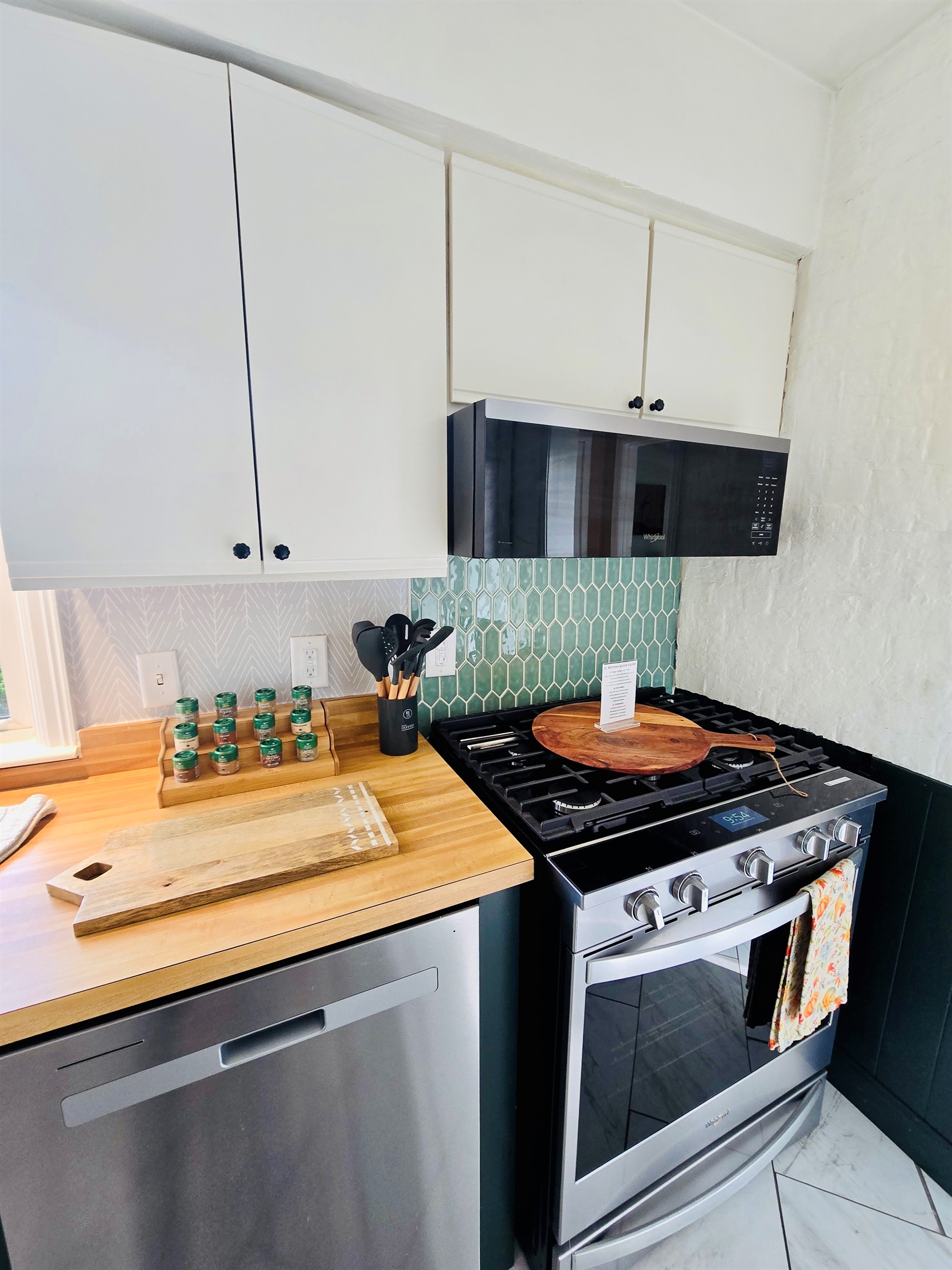 Ready to cook, bake, and gather—this kitchen features a sleek dishwasher, stainless range with microwave hood, and all the essentials: spices, utensils, and even a pizza peel for your next alfresco masterpiece.