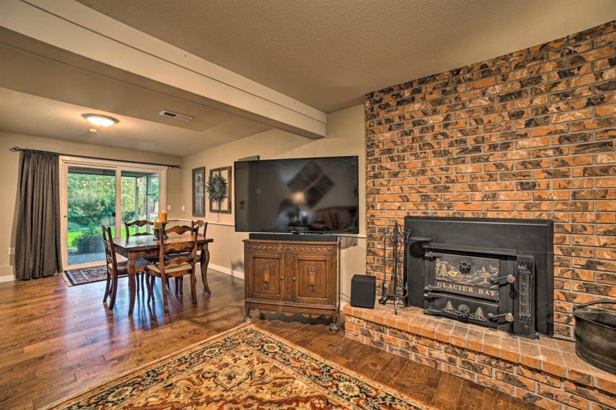 Family room downstairs with wood-burning fireplace, smart TV, and a game table.