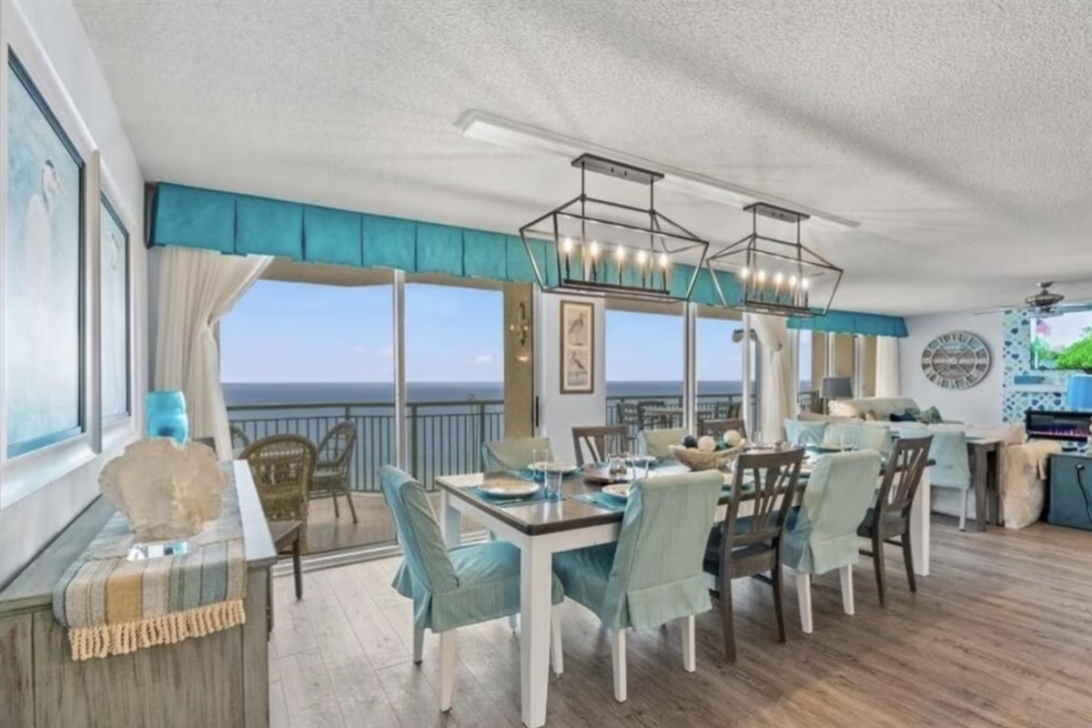 The large dining table in the open-concept living space seats a large family, and features a wall of sliding glass doors for incredible ocean views.