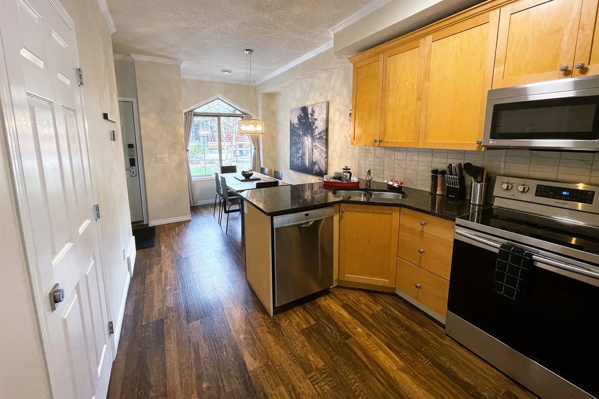 Open concept kitchen, connecting dining area with the living room.  Well equipped with stainless steel appliances, granite counter tops, pots, pans, and more...