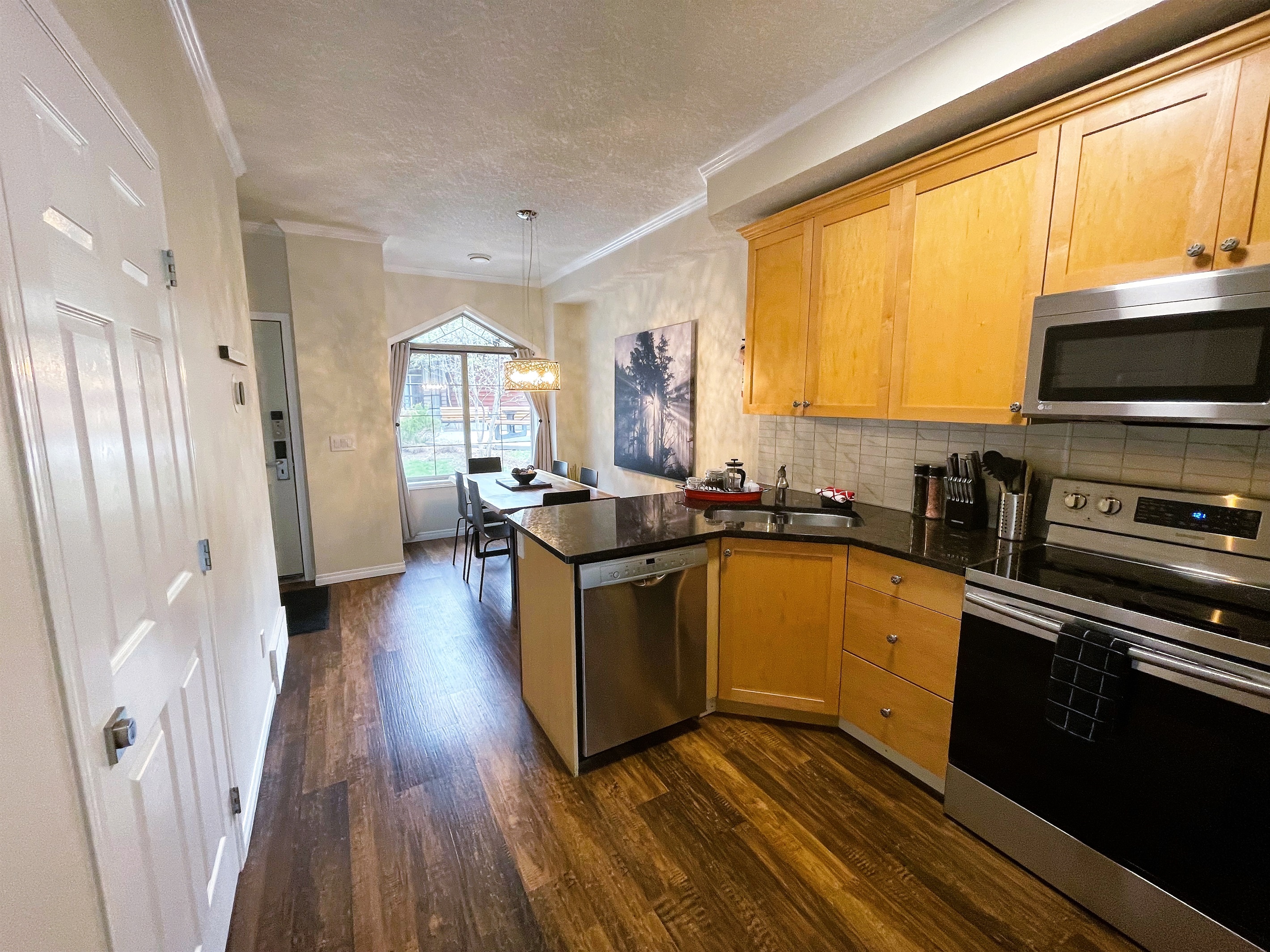 Open concept kitchen, connecting dining area with the living room.  Well equipped with stainless steel appliances, granite counter tops, pots, pans, and more...