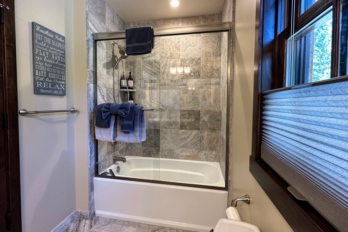 The main floor bath features a tub/shower, sink, and toilet—ready to keep everyone refreshed whether they’re coming from the living room or bunkroom.