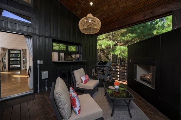 Unwind fireside in the treetops — this covered patio blends forest views, cozy seating, and open-air serenity.