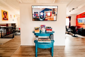 A cozy corner where a TV stands ready for streaming marathons, flanked by shelves stocked with board games.