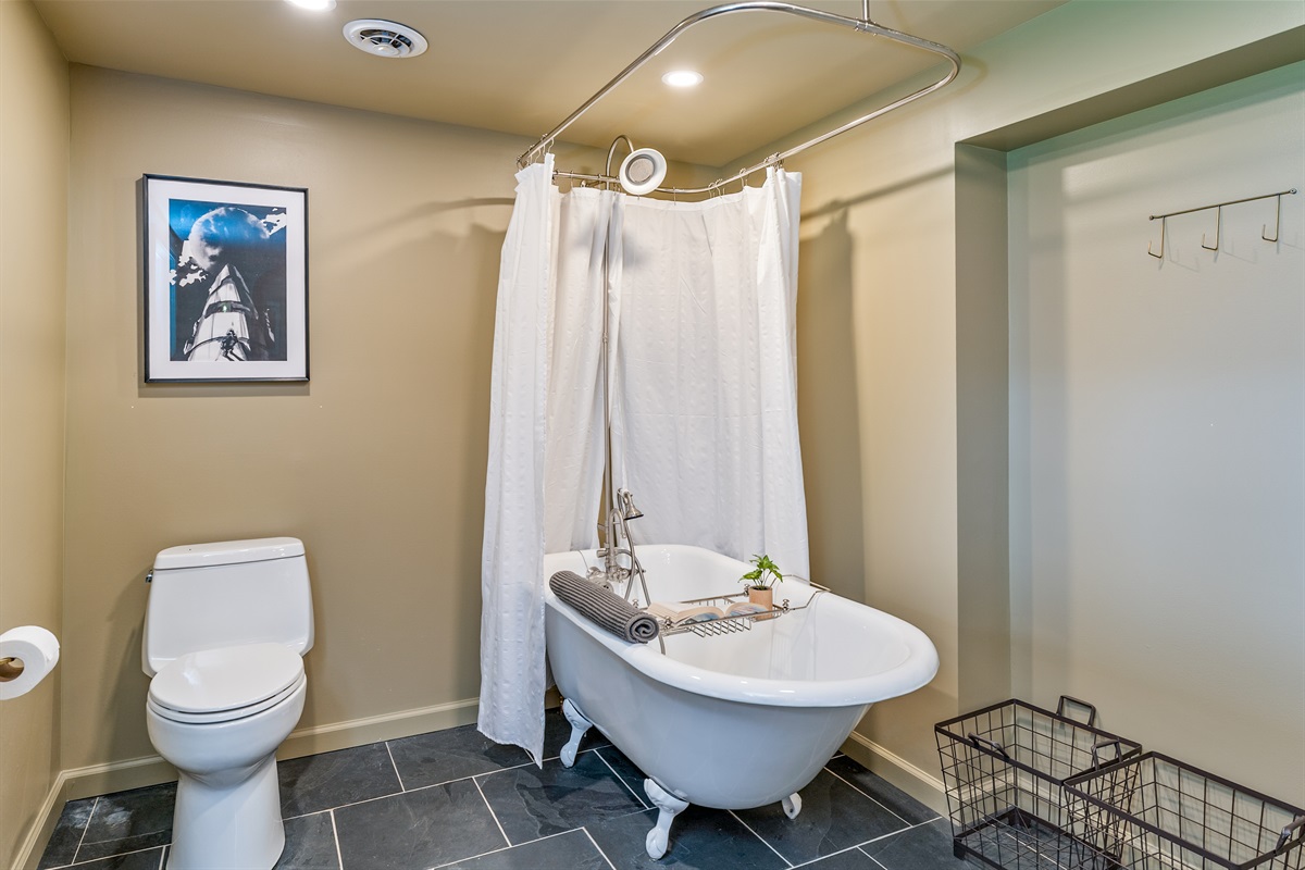 Enjoy spa-like vibes in this stylish bathroom, complete with elegant fixtures, soft lighting, and a deep soaking claw foot tub.
