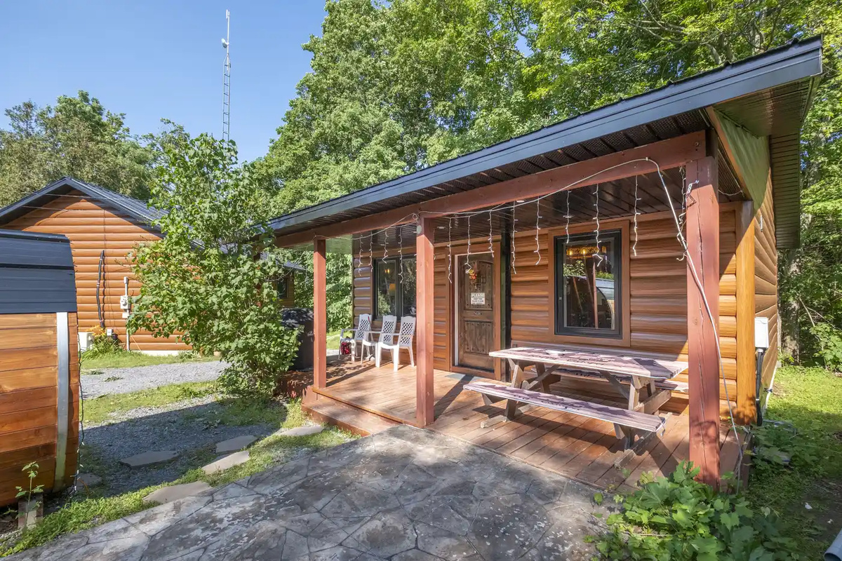 Front view of Cottage #5 with covered porch and rustic exterior