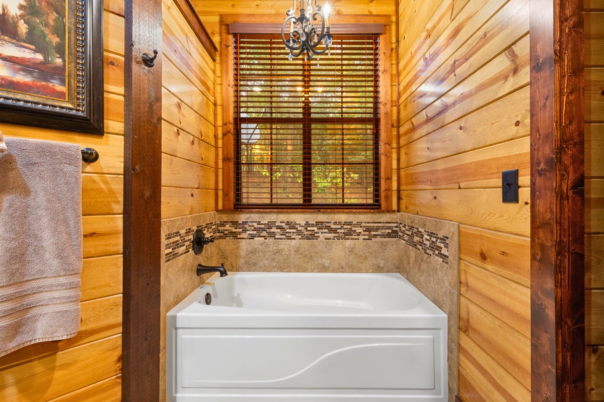 Peaceful retreat with a deep tub and natural light from the window.