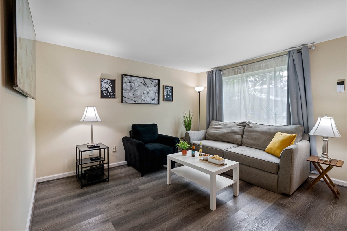 This thoughtfully decorated room features a neutral-toned sofa accented with vibrant yellow throw pillows