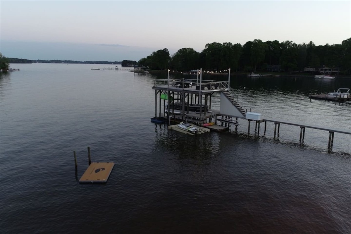 View of dock from drone with paddleboards, kayak, and paddleboat available for guest use.
