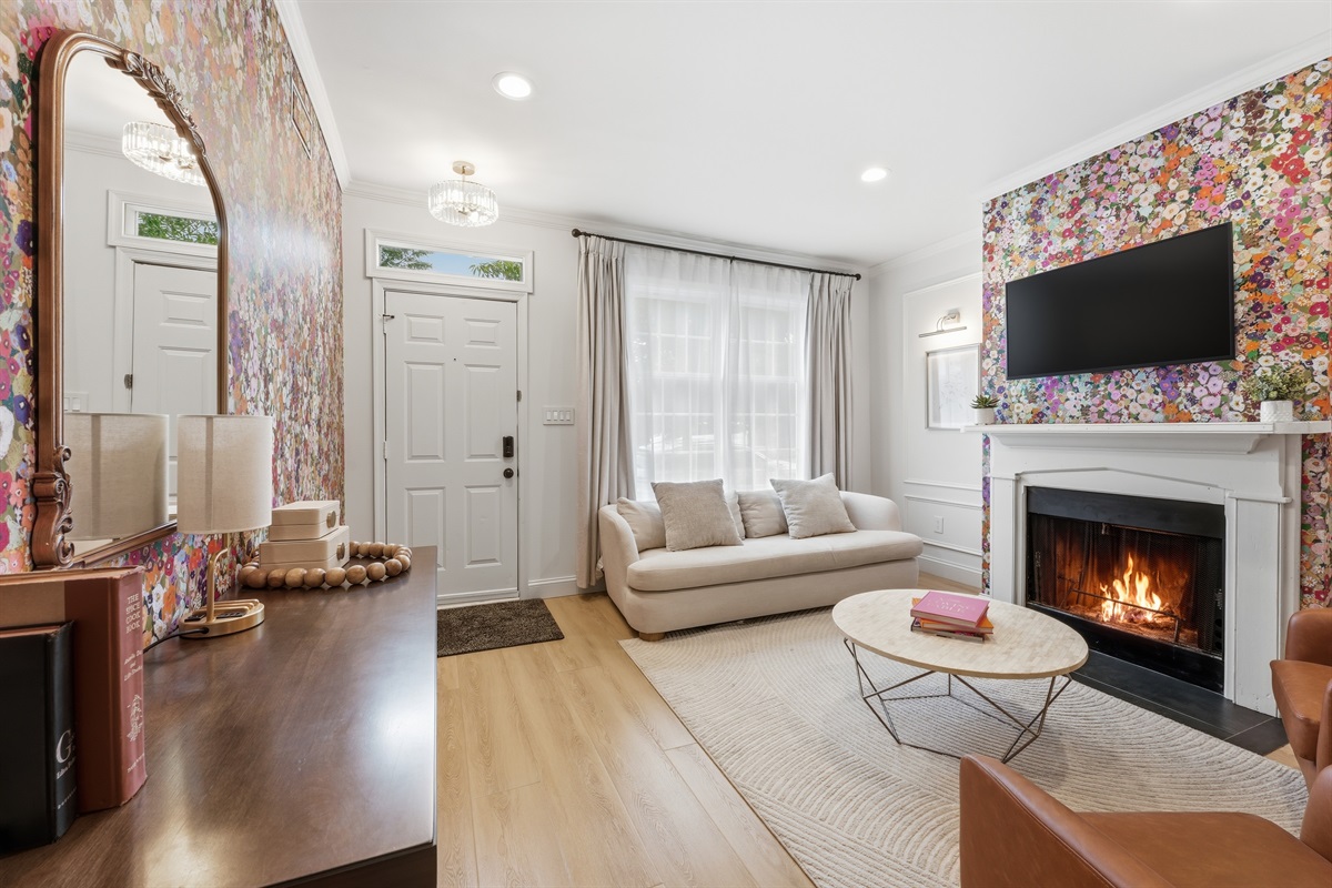 Elegant sitting area with abundant natural light, designer finishes, and a decorative fireplace that creates a warm boutique-hotel atmosphere