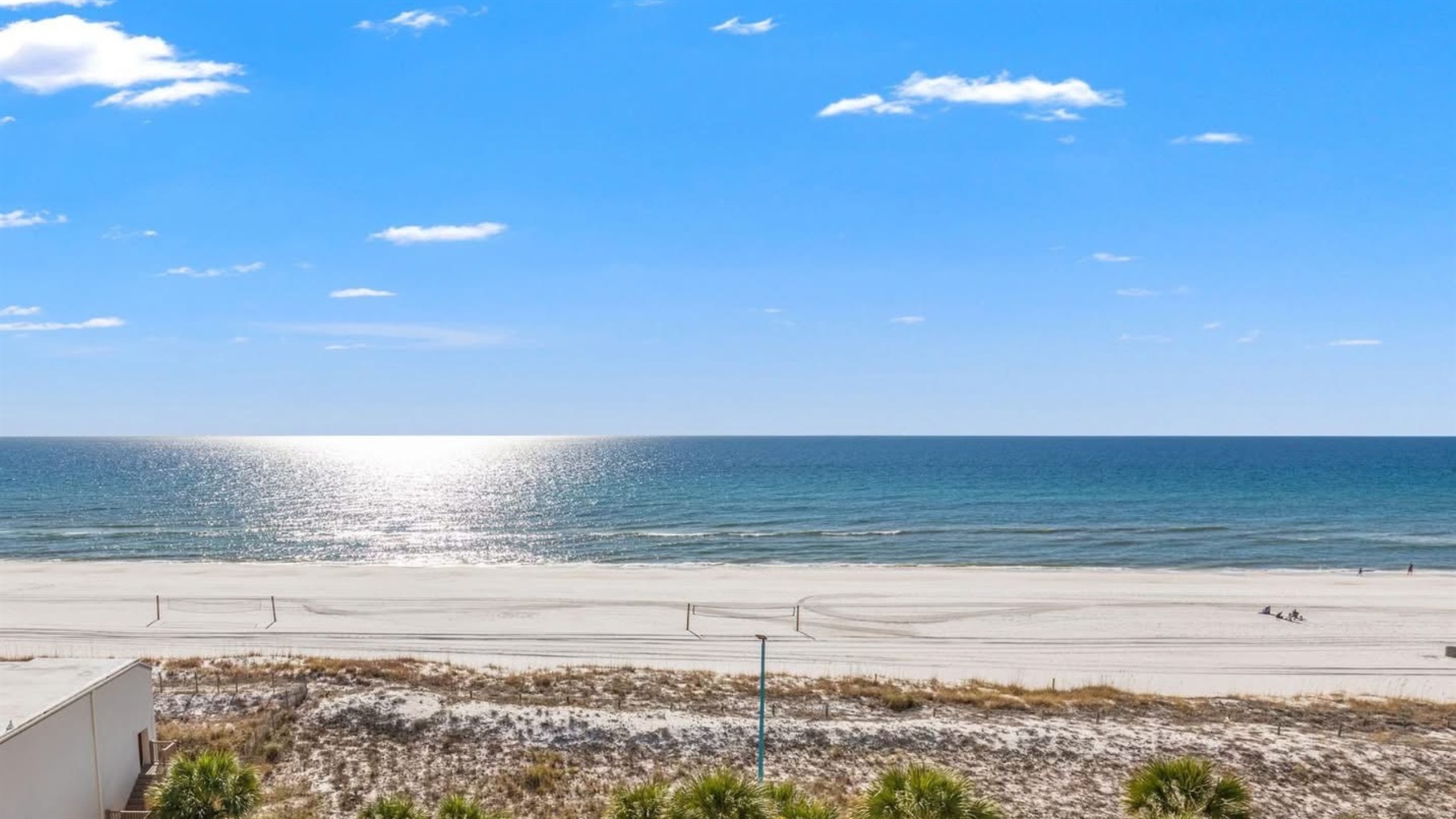 Private balcony with expansive, unobstructed Gulf views — your front-row seat to the emerald water and sugar-white sand.