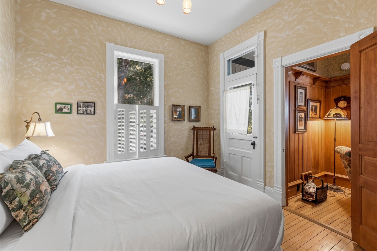 View into sitting room from bedroom doorway w/ soft lighting & vintage decor