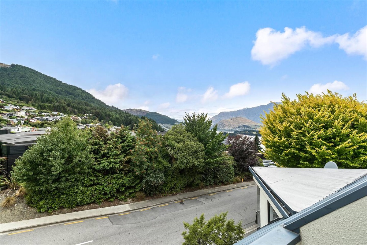 Fernhill Mountain Escape’s balcony gives the dining area an outdoor extension, with a BBQ, leafy outlook and Lake Wakatipu glimpse above Queenstown.