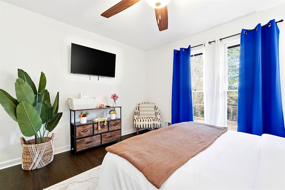 Upstairs bedroom located to the right, featuring a floral-inspired design and a comfortable double bed. Includes a smart TV and easy access to a shared bathroom. This room includes 2 full-body towels, 2 washcloths, and 2 hand towels for your stay.