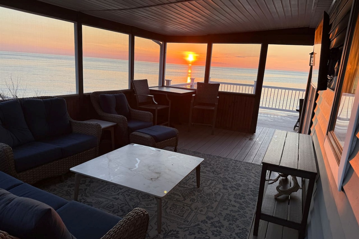 Enjoy breathtaking sunset views from the comfort of this elegant, screened-in porch. This serene luxury space features plush wicker seating, perfect for relaxing as you watch the sun set.