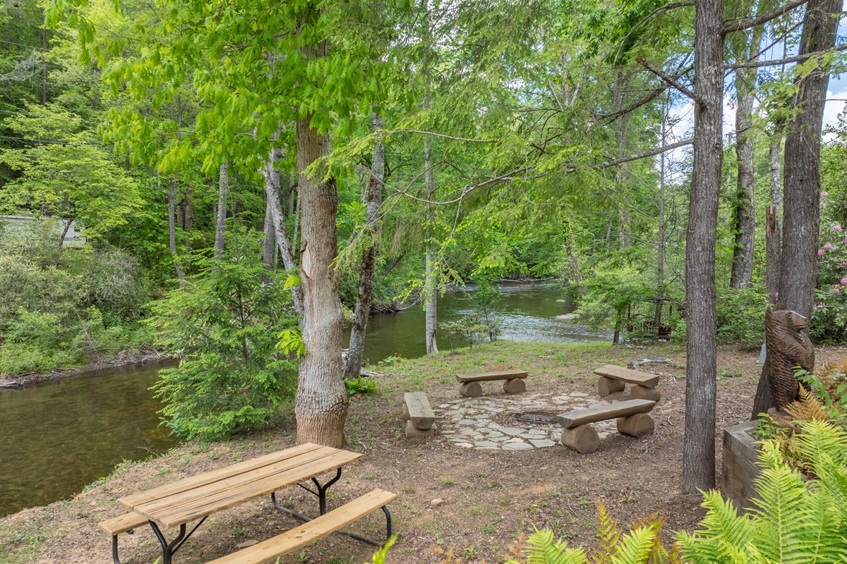 The garden area offers a peaceful outdoor gathering space with a picnic table, fire pit, and beautiful views overlooking Snowbird Creek.