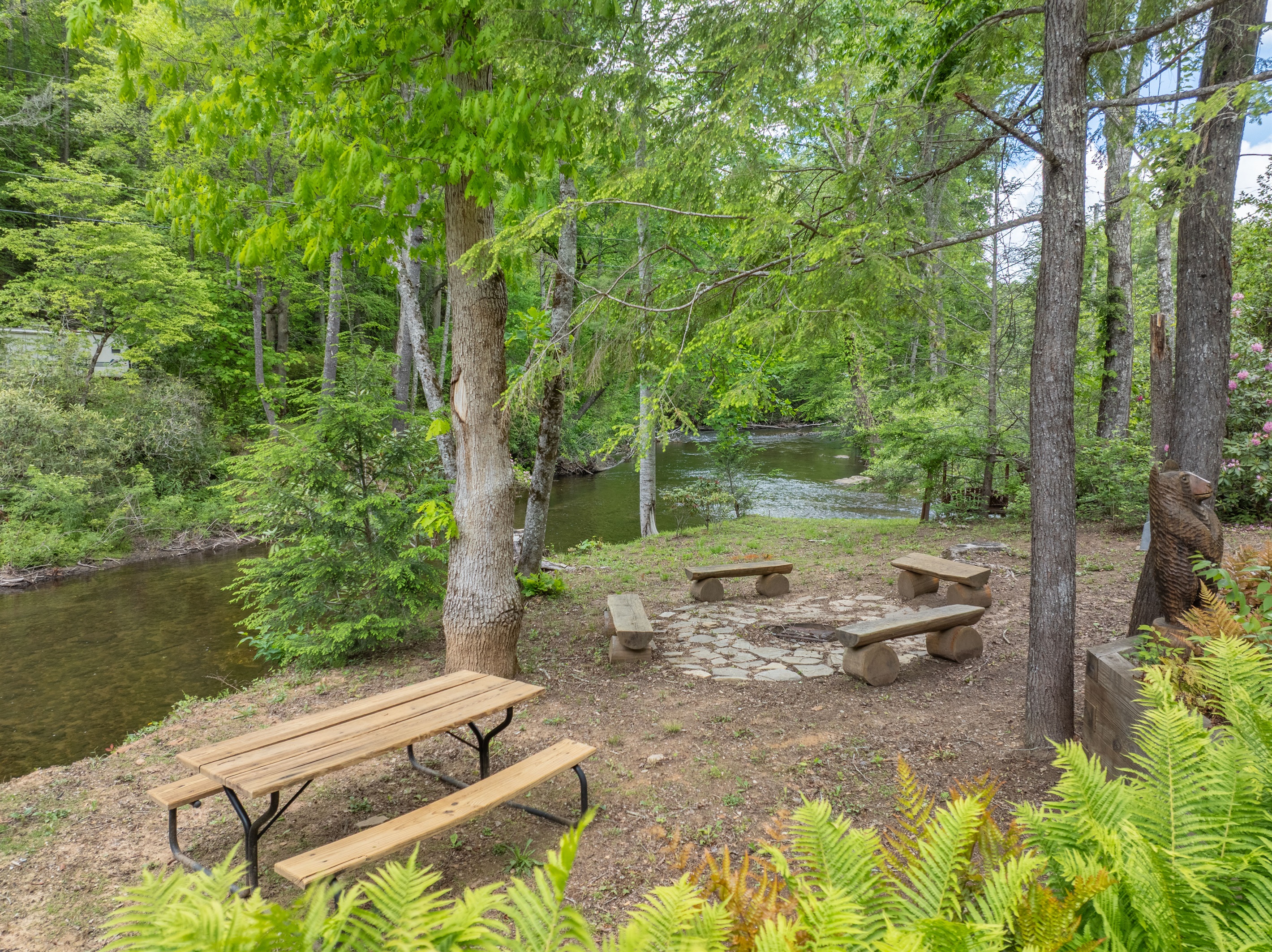 The garden area offers a peaceful outdoor gathering space with a picnic table, fire pit, and beautiful views overlooking Snowbird Creek.