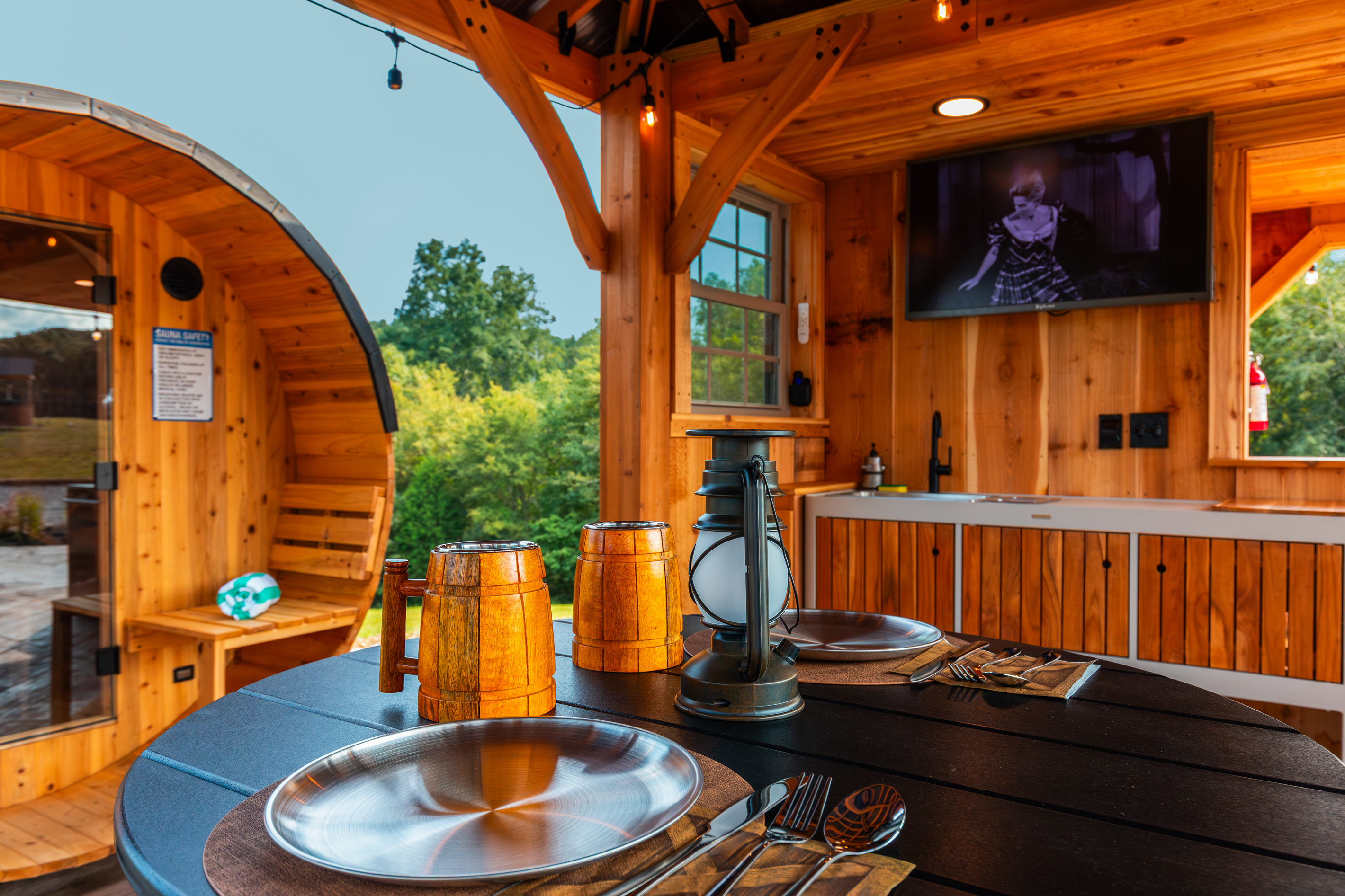 Covered pavilion dining with outdoor TV, sauna views, and western-inspired details.