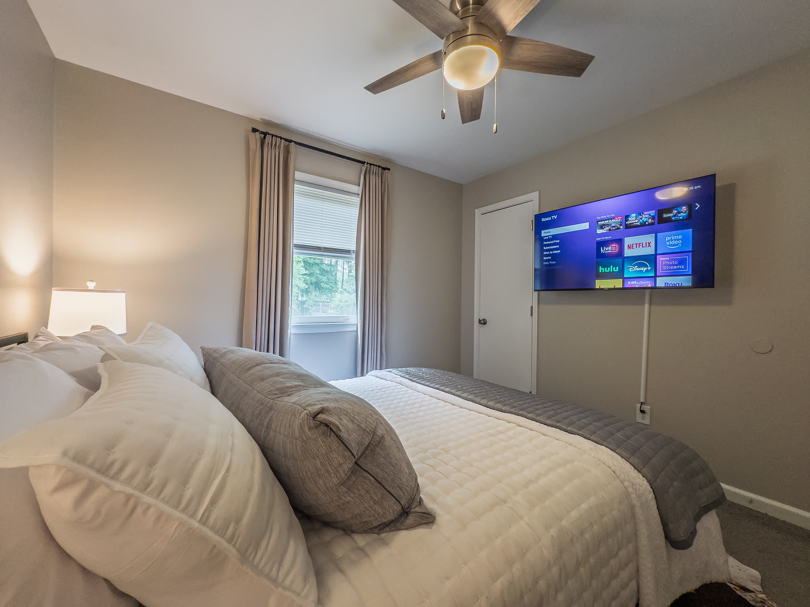 Queen bed, 55" Smart TV, ceiling fan, two led-light nightstands with multiple charging ports, two multi-light function lamps, blackout curtains, and full closet.