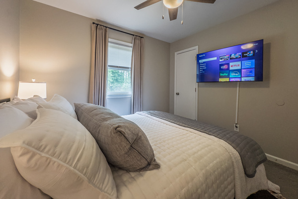 Queen bed, 55" Smart TV, ceiling fan, two led-light nightstands with multiple charging ports, two multi-light function lamps, blackout curtains, and full closet.