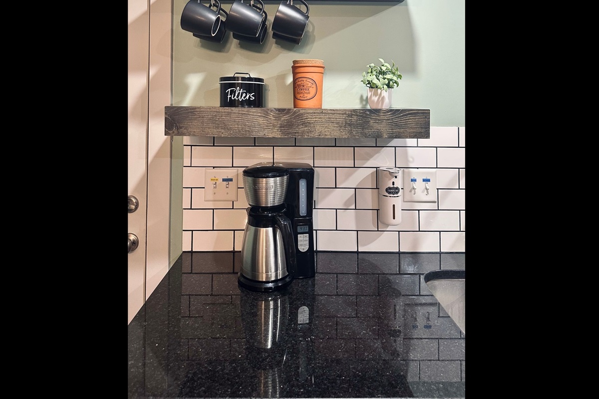 Dedicated coffee station complete with mugs, coffee maker, filters, and coffee to make mornings easy and inviting.