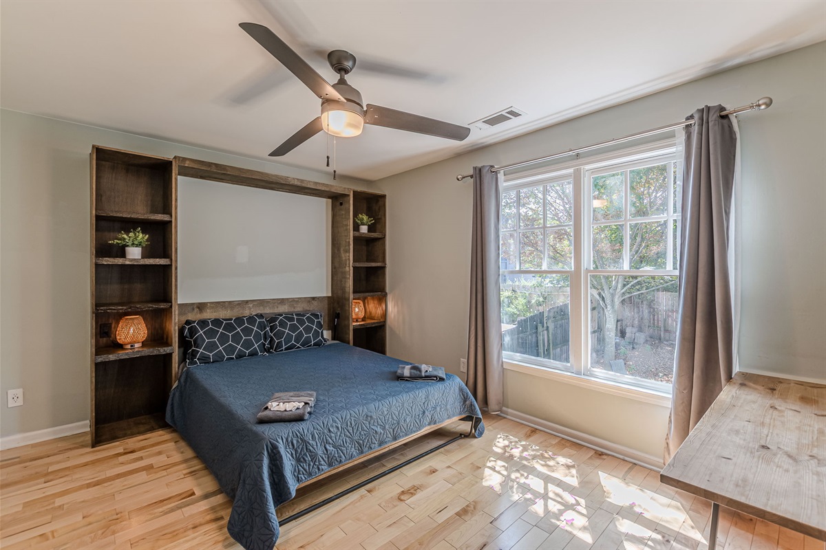 Upstairs bedroom with a queen bed, lots of storage, and sun-filled double windows.