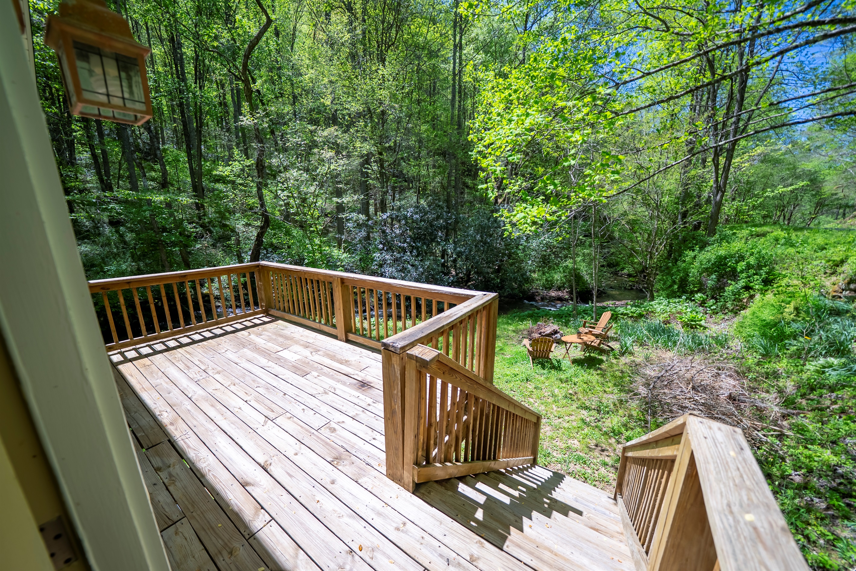 Private deck overlooking Yellow Creek, the spacious yard, and a cozy wood-burning fire pit.