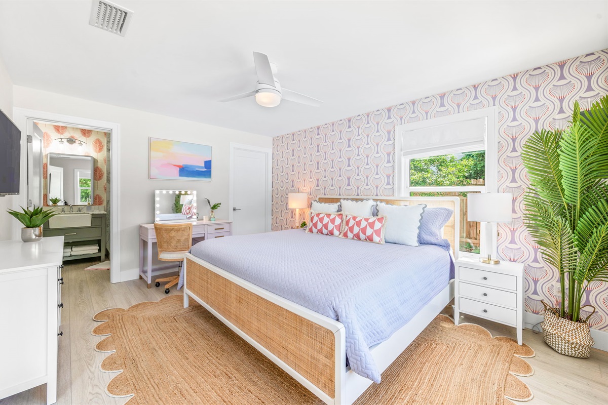 Relax in our downstairs master bedroom featuring a plush king bed, a large TV for your entertainment, a stylish ensuite bathroom, and a handy desk for any work or planning.
