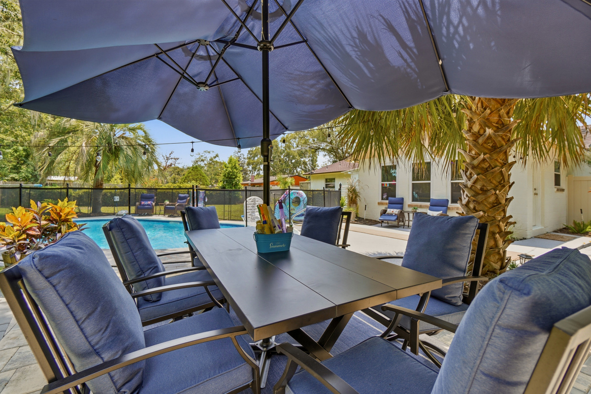 The shaded dining area overlooks the private pool, creating an inviting setting for meals and conversation.