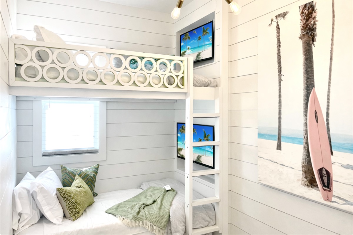 Custom bunk room with built-in TVs and a trundle bed. The kids will have a blast!