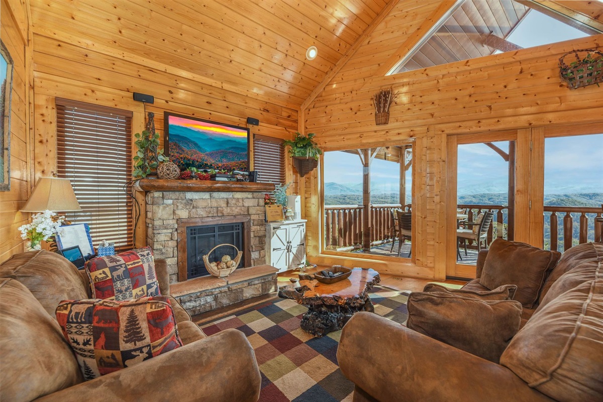 - Relax in the cozy living area featuring plush sofas and a stone fireplace centerpiece   - Large windows frame panoramic Smoky Mountain views from every angle   - A perfect space to unwind and enjoy nature&rsquo;s beauty from the comfort of your cabin