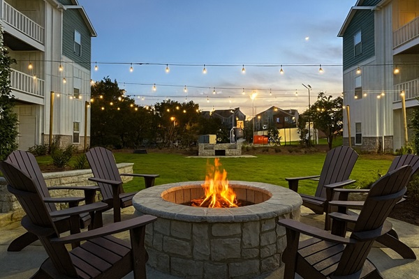 shared court yard with fire pit string lights and grilling area.