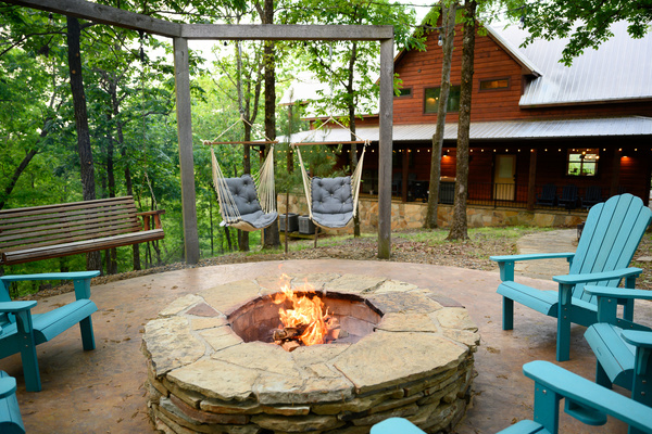 Stone fire pit with adirondack seating and swings.