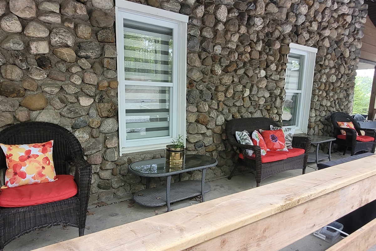 Front covered porch of cottage with comfortable seating facing parking area