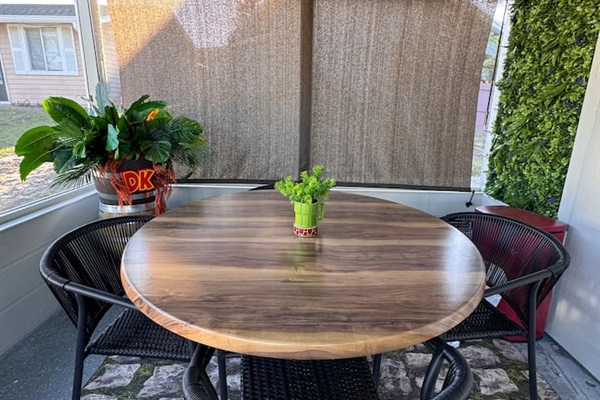 Cozy outdoor Donkey Kong inspired dining set on the patio of Mario's Mini Mansion, Clermont, FL! Round table with comfortable woven chairs offers a relaxed spot to eat, chat, or play games.