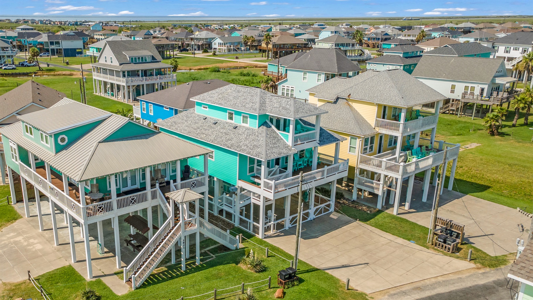 Sandy Toes: An aerial view of our turquoise beach house (center) shows its spacious design, balconies, and prime location just minutes from the beach.