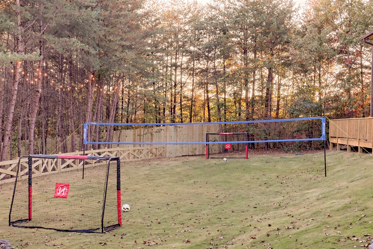 Large yard with soccer goals and a volleyball net for fun outdoor play.